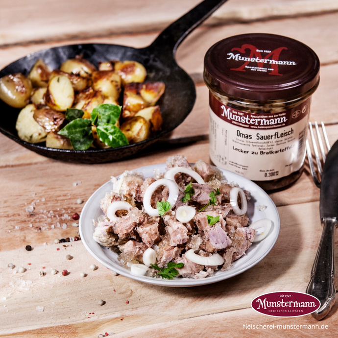 Sauerfleisch, Bratkartoffeln auf Tellern angerichtet